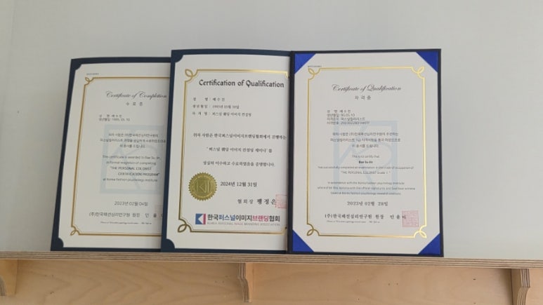 Three framed Korean personal colour and image consulting certificates on the studio shelf