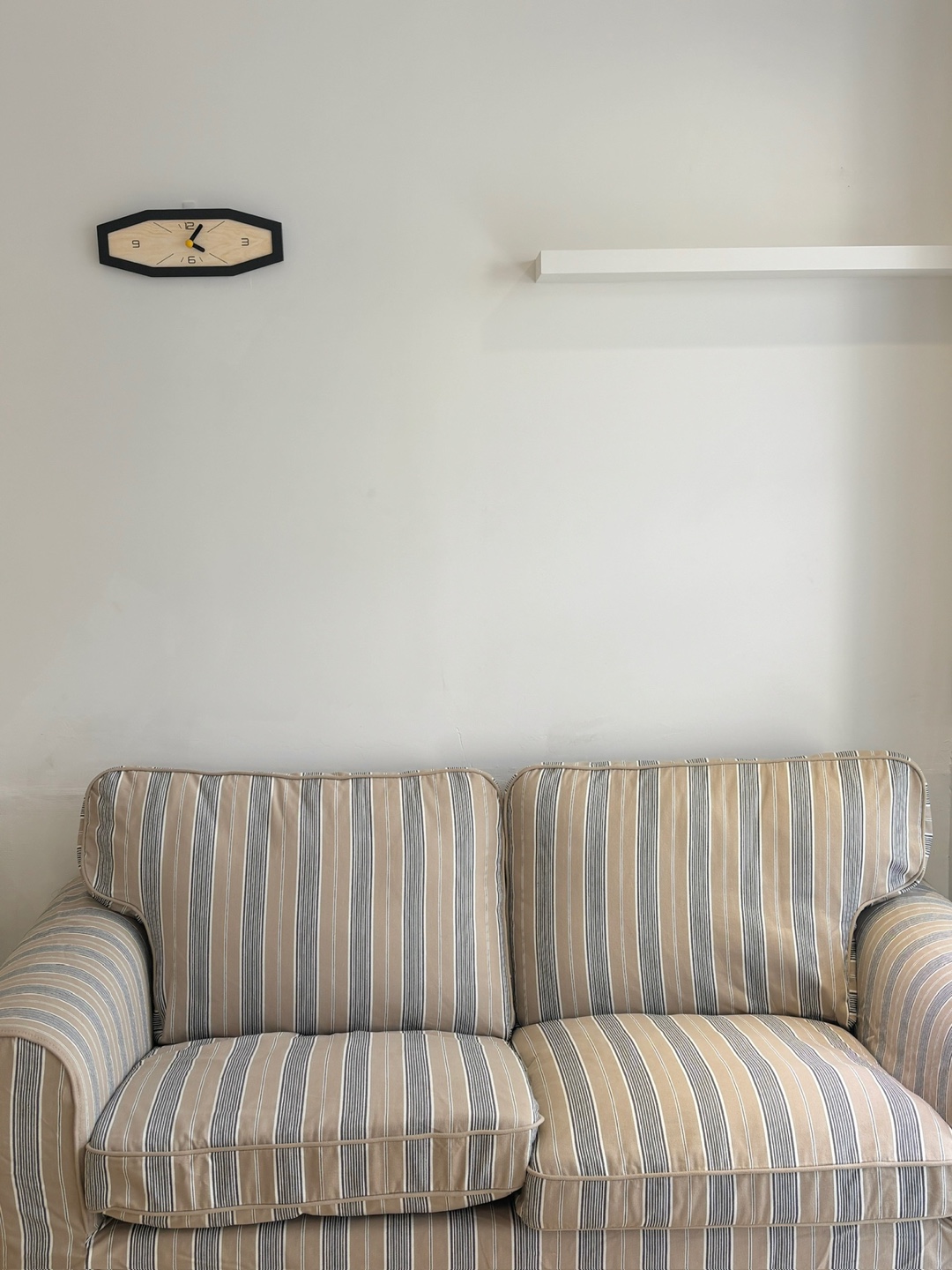 Waiting sofa and wall clock at the studio entrance