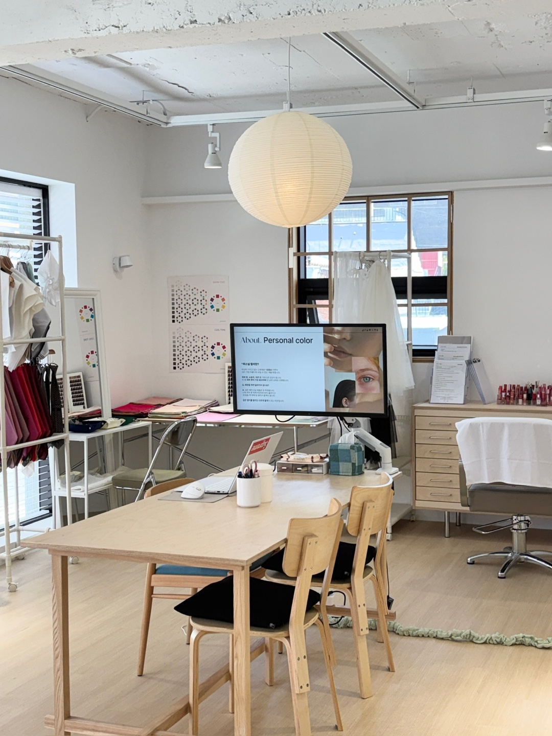 The draw me studio in Jeonpo, Busan — consultation table, colour charts and drape wardrobe in natural light
